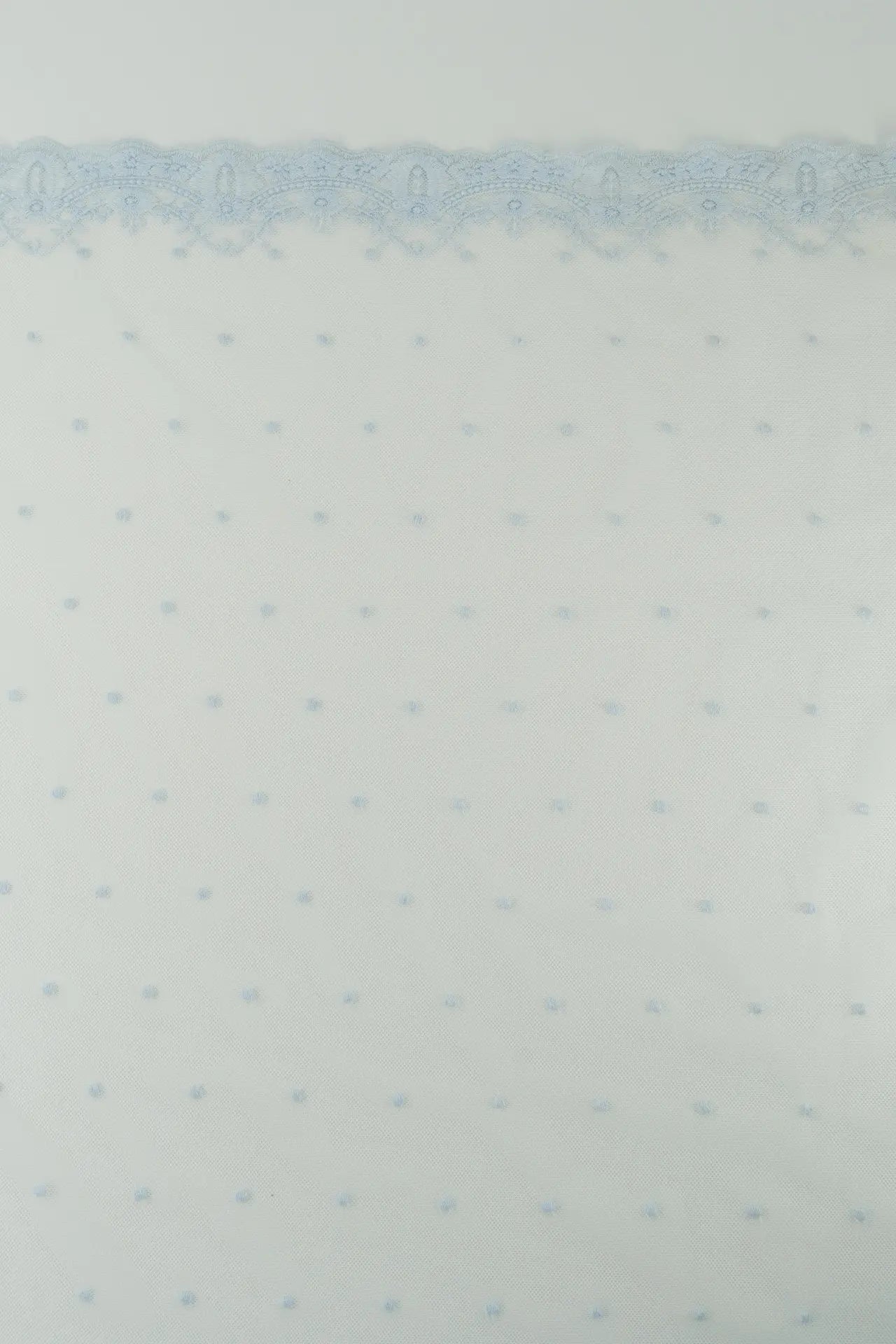 Tule bordado com plumeti azul claro e rebordo pequeno.