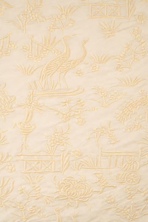 Tela bordada con chinitos color crema