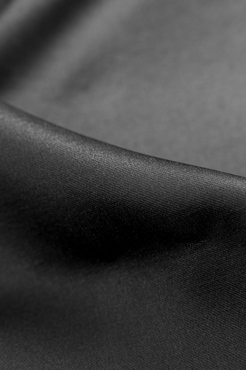 Tejido de raso mikado color negro. Tejido con cuerpo y brillo.